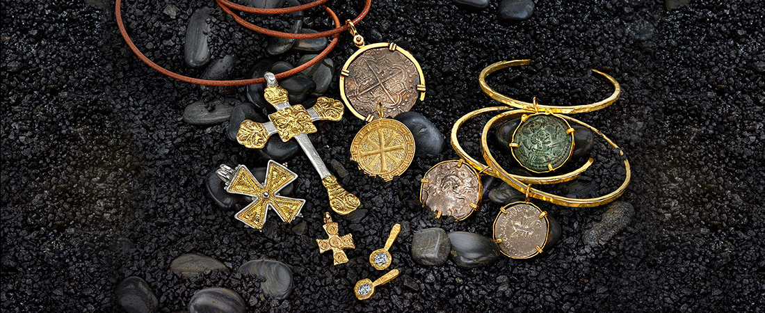 Variety of ancient coins, gemstones and artifacts set in 22k gold on leather cord necklaces.